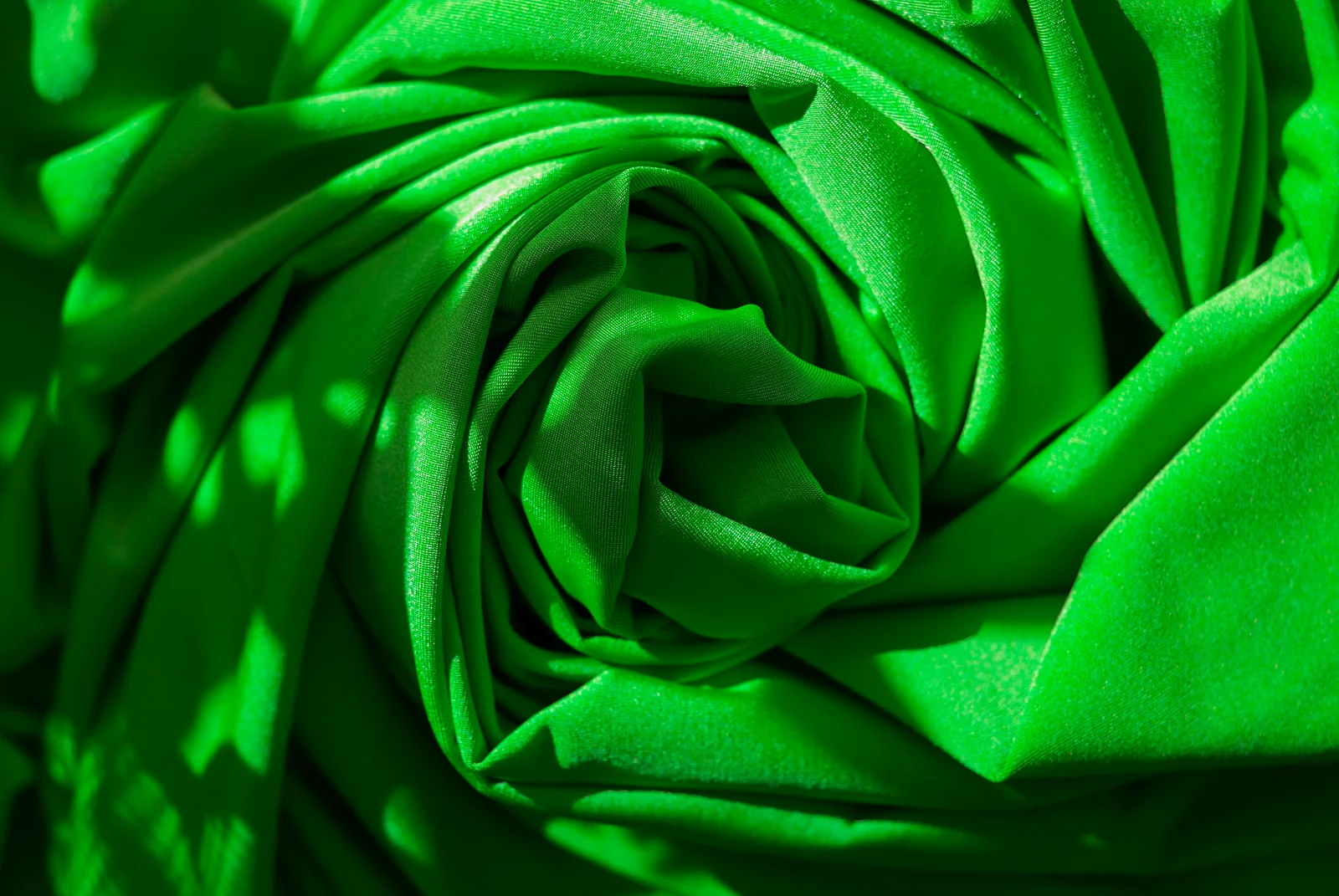 Green fabric folded into soft pleats.