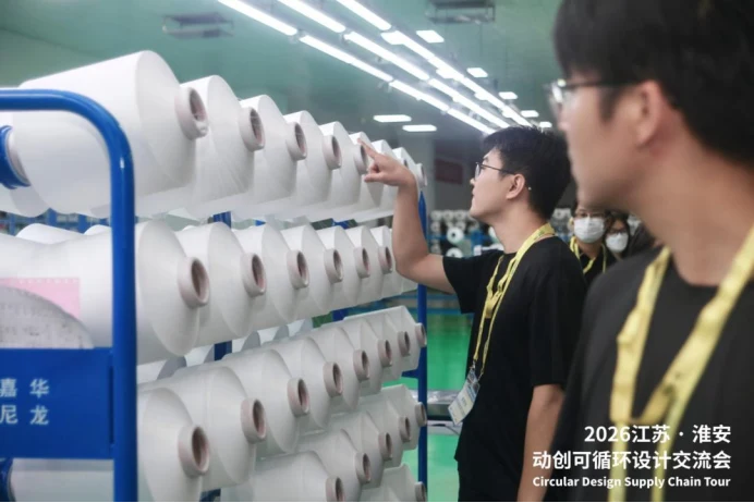 Participants examine yarn during the September 2026 circular-design supply-chain tour in Huai’an.